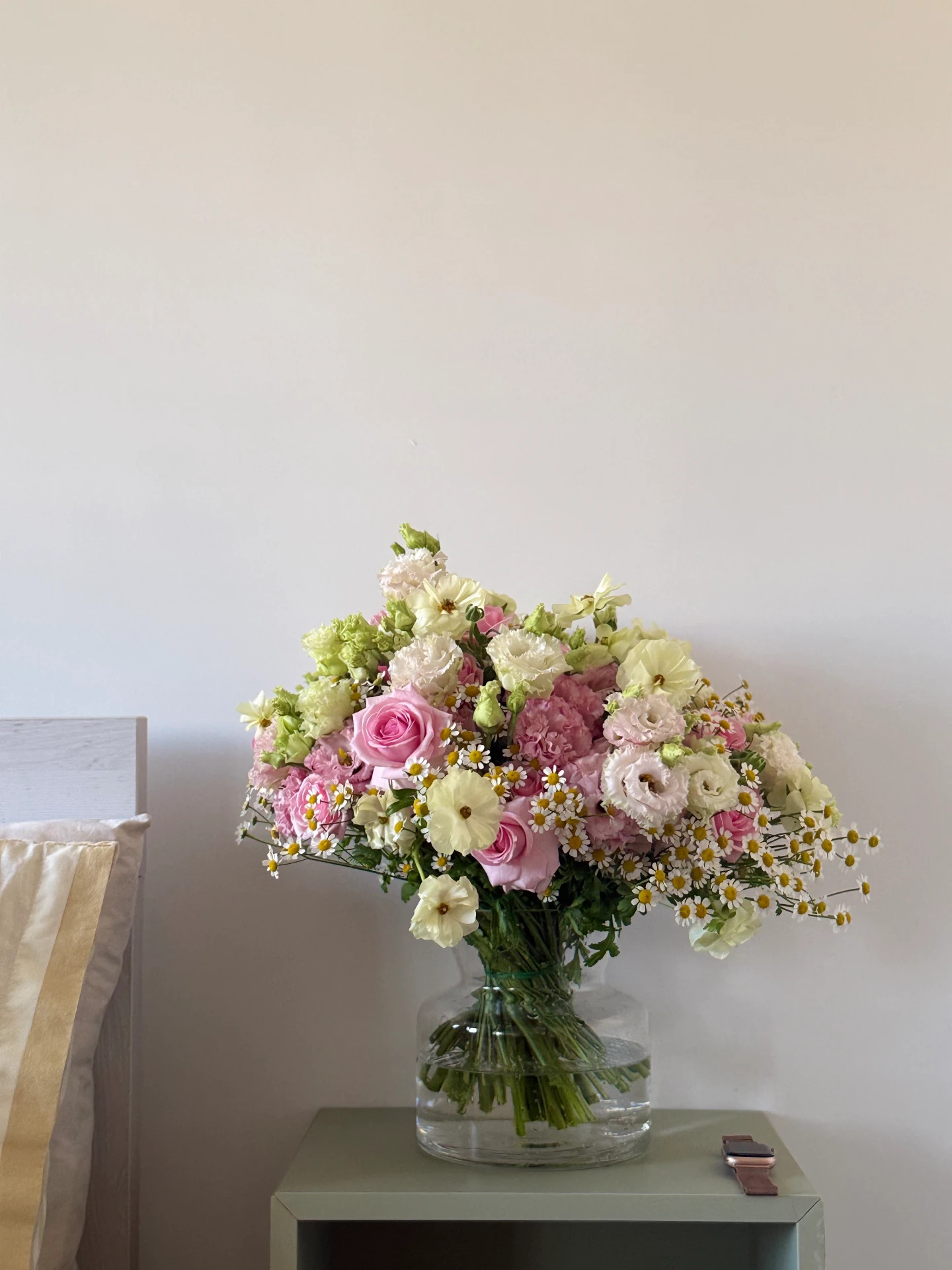 Pastel pink and cream bouquet of roses, lisianthus and chamomile in a glass vase